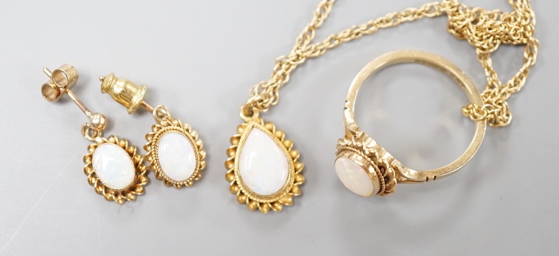 A modern suite of 9ct gold and white opal jewellery, comprising a ring, pendant on chain and pair of earrings, gross weight 9.1 grams.